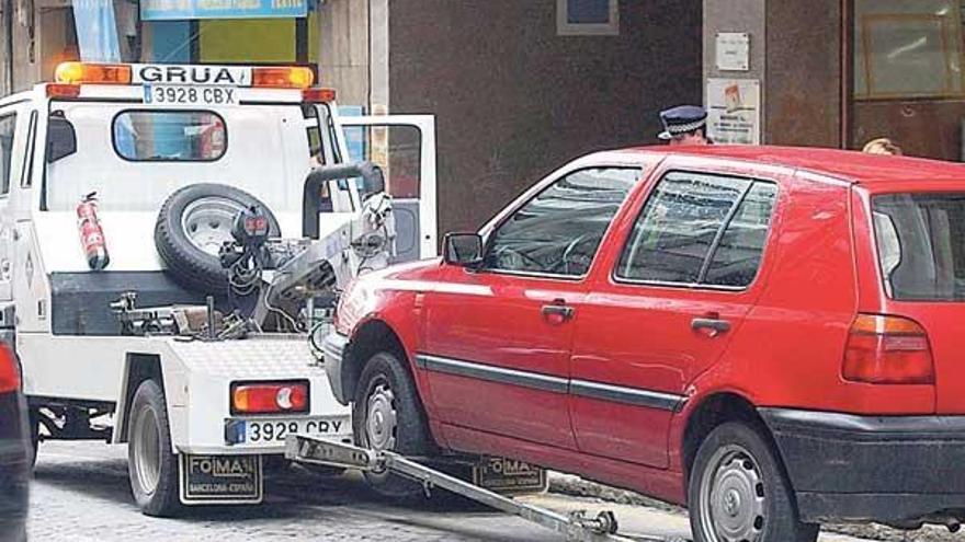 Un vehículo grúa retira un coche mal estacionado en Ourense.  // Iñaki Osorio