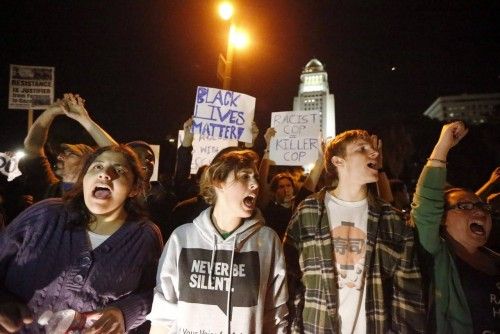 Protesters face off against a line of police during a demonstration outside LAPD headquarters, following the Monday grand jury decision in the shooting of Michael Brown in Ferguson, Missouri, in Los Angeles