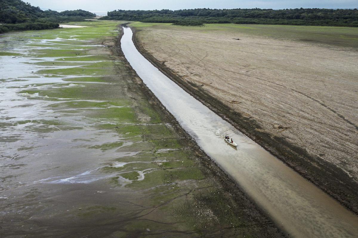 Una embarcación cruza lo que resta de las aguas en el Lago do Aleixo¡, en el Amazonas, en Manaos (Brasil).