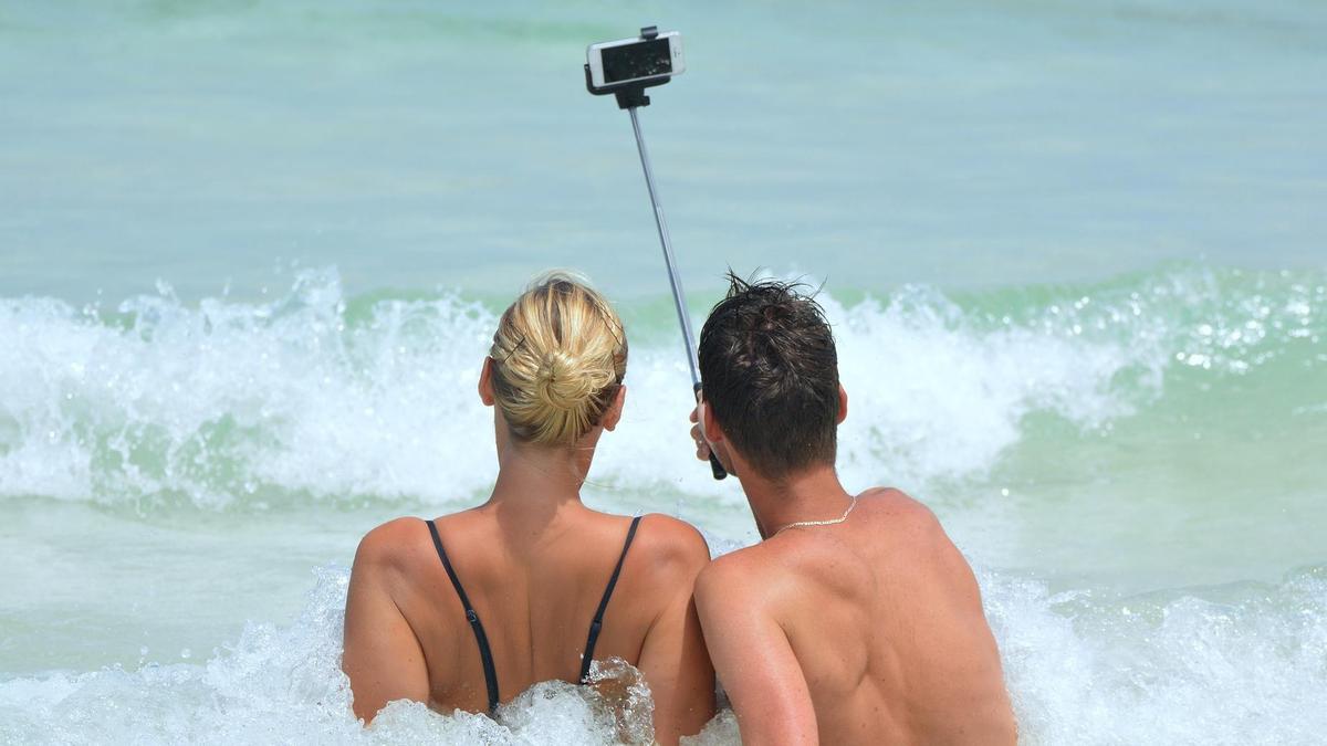 Una pareja haciéndose un selfie en la playa