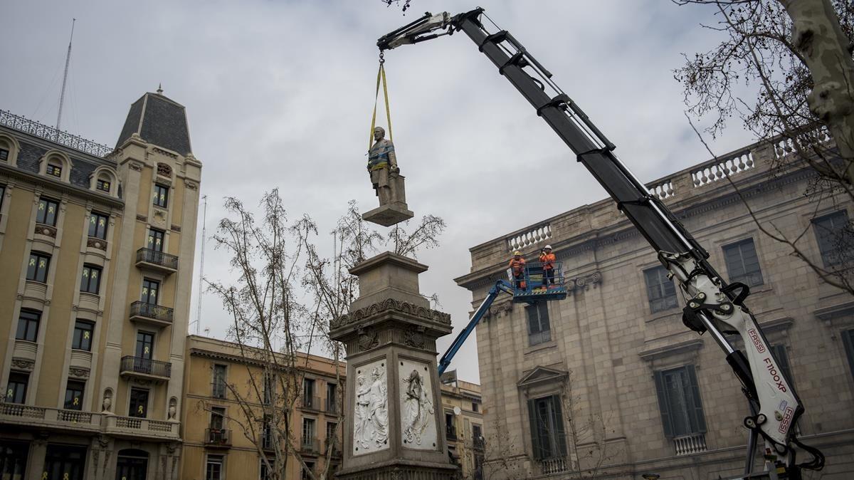 Una grúa levanta la estatua de Antonio López para bajarla de su peana, en la plaza que lleva su nombre, este domingo.