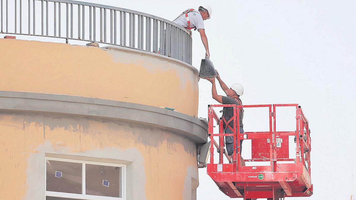 Imagen de archivo de dos obreros trabajando en el exterior de un edificio de la capital de la Plana.