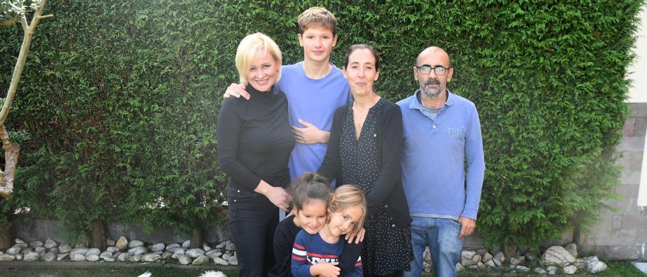 La ucraniana Oksana Hryschchenko, a la izquierda, con su hijo Yuri y la familia de acogida, Alma Ponlla y Javier Aragón. Abajo, la pequeña Ariana con Dani.  | // CARLOS PARDELLAS