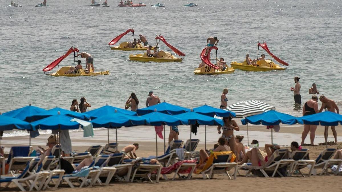 Turistas en sus hamacas en una playa de Canarias.