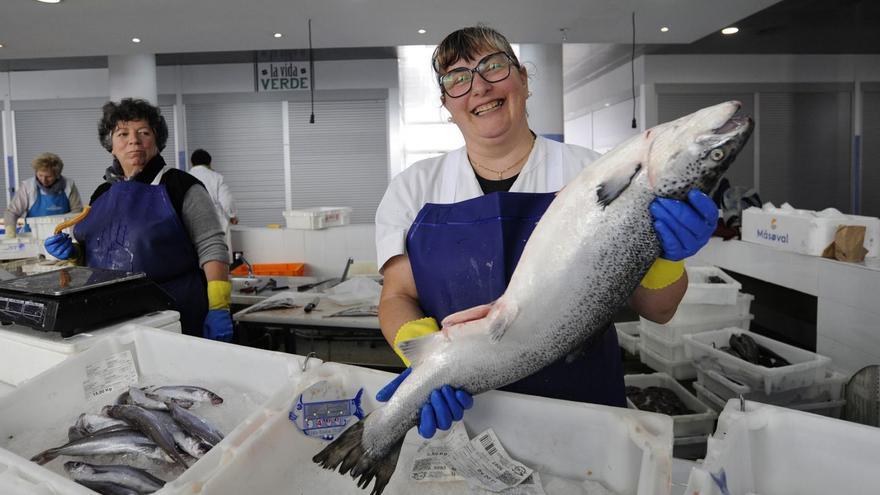 Una dependienta de Chedas posa con un salmón en el Mercado de Abastos. |  Bernabé/ Javier Lalín