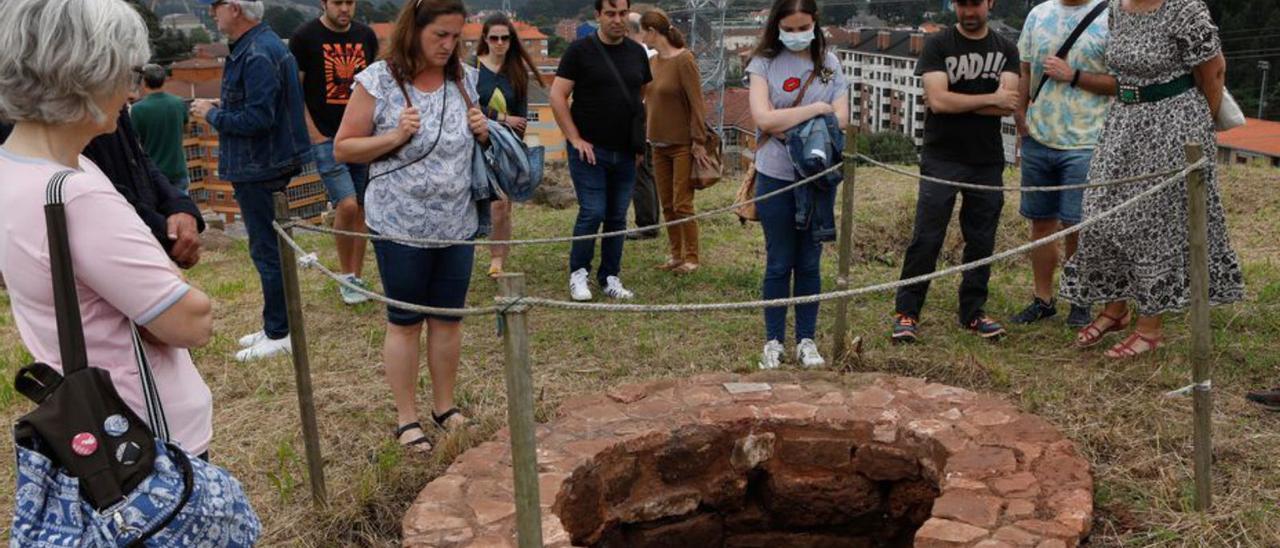 Los visitantes contemplan el pozo del castilo de Gauzón. | Mara Villamuza