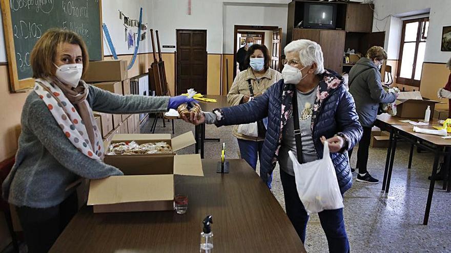 Arriba, la venta de las rosquillas. En los círculos, Rosa Mari Mediavilla muestra una mascarilla de San Blas y el sacerdote Fernando Díaz durante la eucaristía. | Ángel González