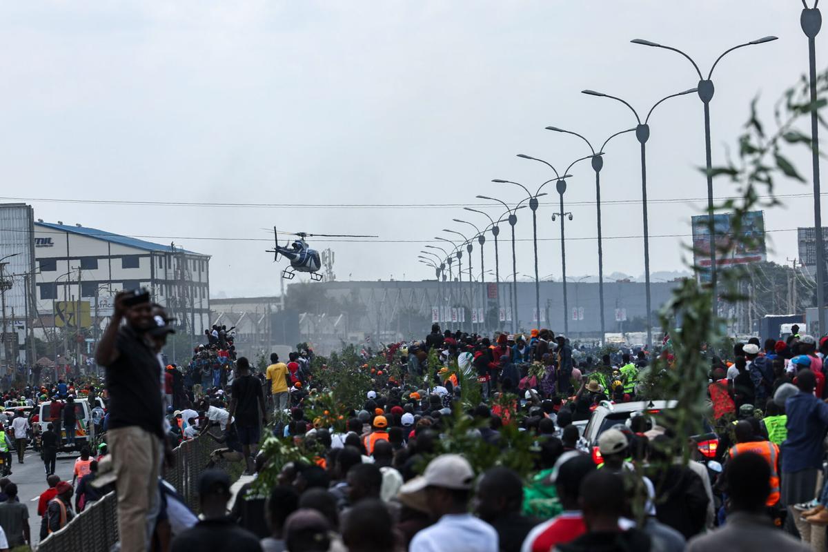 NAIROBI (Kenya), 16/10/2025.- Supporters of the late Kenyan Prime Minister Raila Odinga follow the vehicle transporting his body to a stadium for public viewing after arriving at Jomo Kenyatta International Airport in Nairobi, Kenya, 16 October 2025. Odinga, 80, who spent many years as an opposition leader, passed away in India on 15 October 2025, while receiving medical treatment. (Kenia) EFE/EPA/DANIEL IRUNGU