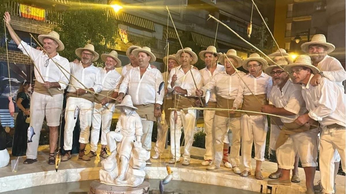 Participantes de los Alardos de Ontinyent disfrazados de 'Peixcaoret' junto a la emblemática figura en la plaza de la Concepció.