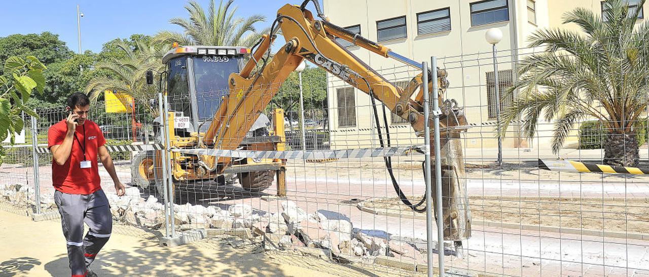 Operarios trabajando delante del edificio Vinalopó, donde se está mejorando la urbanización de la Universidad Miguel Hernández.