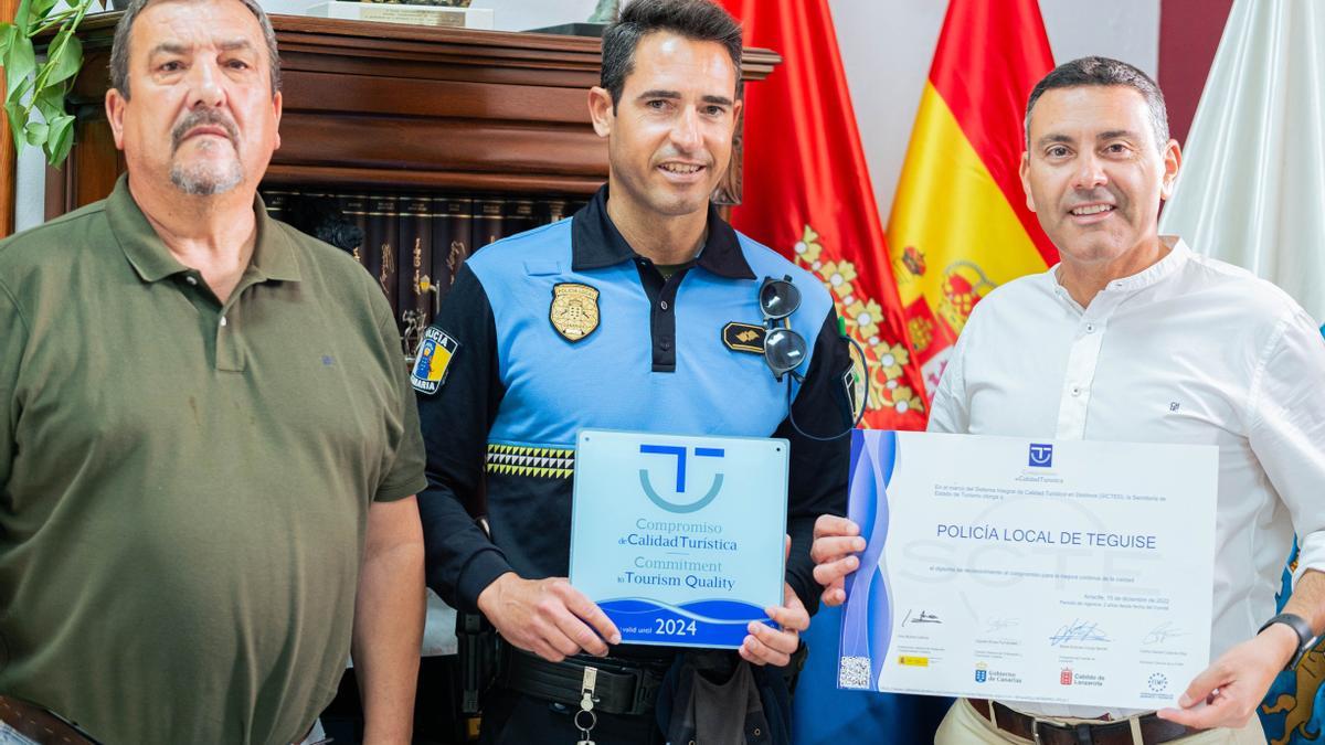 Miguel Ángel Jiménez y Oswaldo Betancort con el policía local mostrando el reconocimiento a la calidad turística en destino para el cuerpo de seguridad municipal.