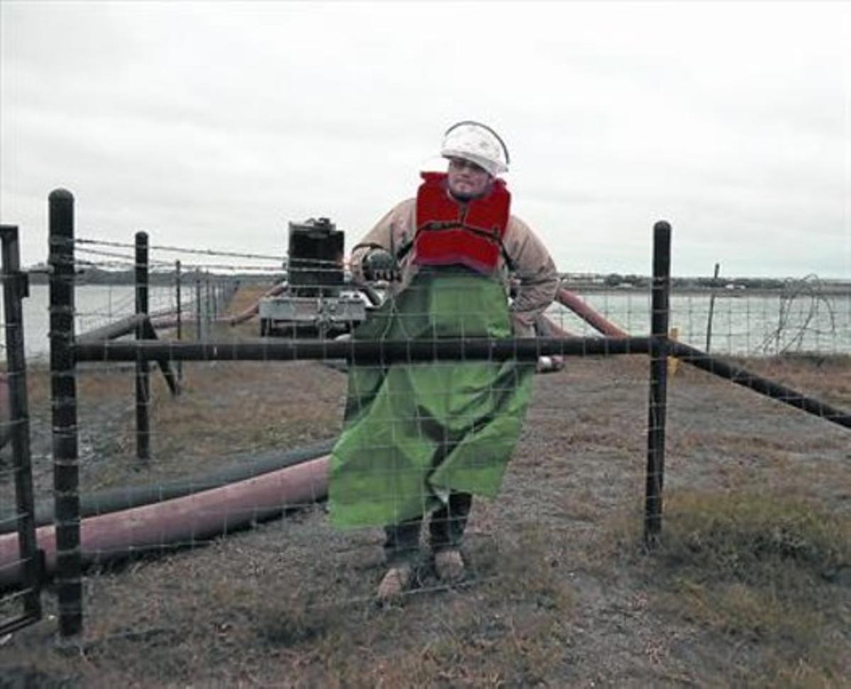 Aturada en la producció 8 Un treballador davant una una bassa d’aigua utilitzada per al ’fracking’ a Kenedy (Texas). Aturada en la producció 8 Un treballador davant una una bassa d’aigua utilitzada per al ’fracking’ a Kenedy (Texas).