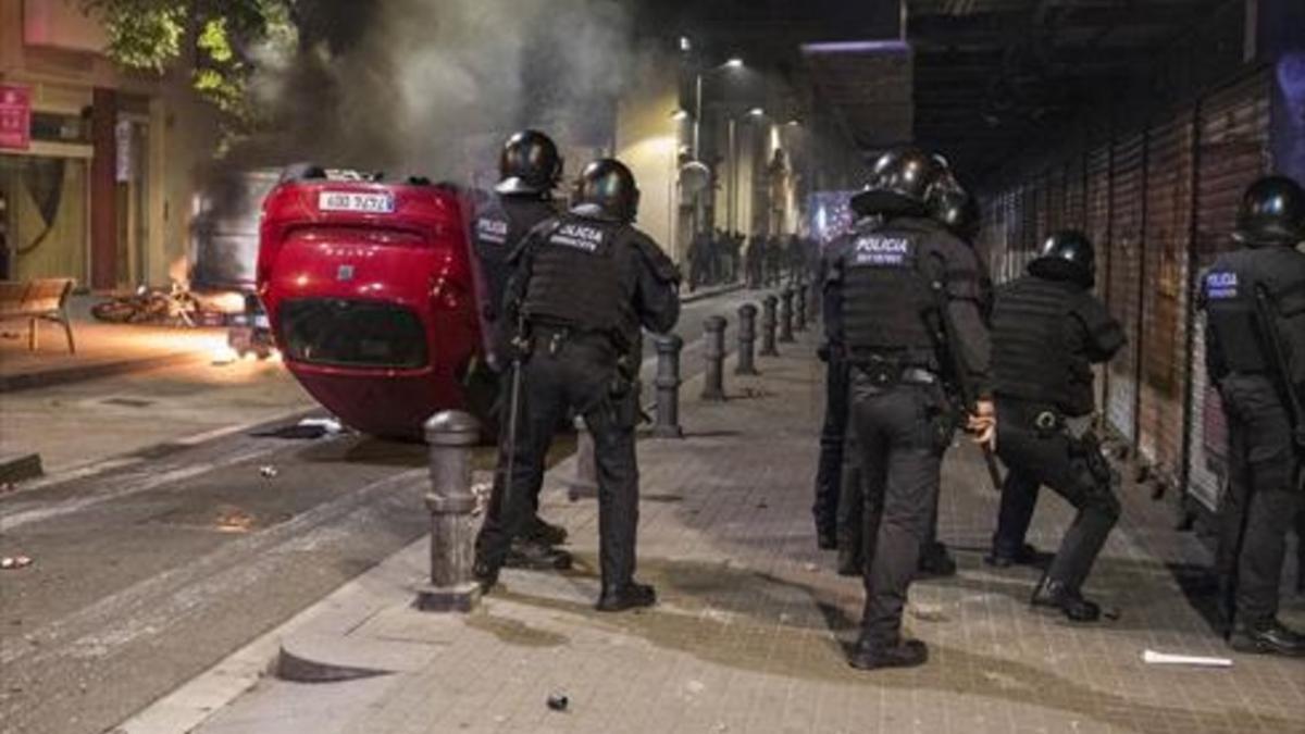 Un vehículo volcado en la Travessera de Gràcia, durante los altercados producidos por los okupas.