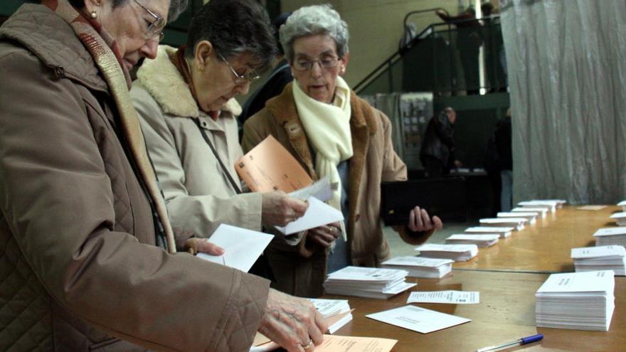 Tres dones davant les paperetes en un col·legi electoral de Girona