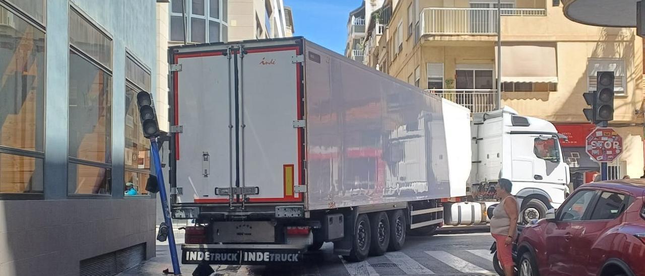 Un camión paraliza el tráfico en el centro de Torrevieja al intentar un giro y derribar un semáforo