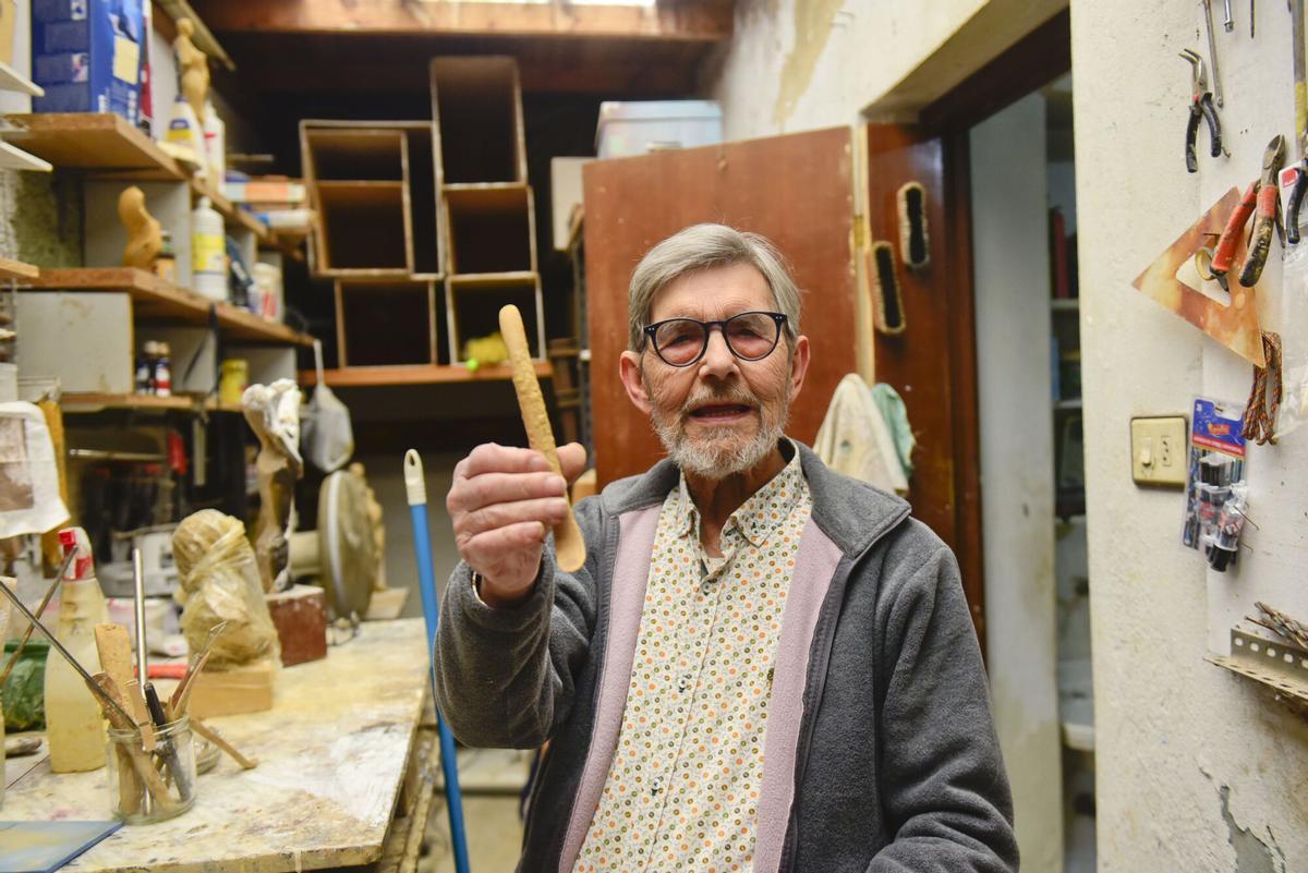 José Castiñeiras posa en su taller con uno de los instrumentos que utiliza para esculpir el barro