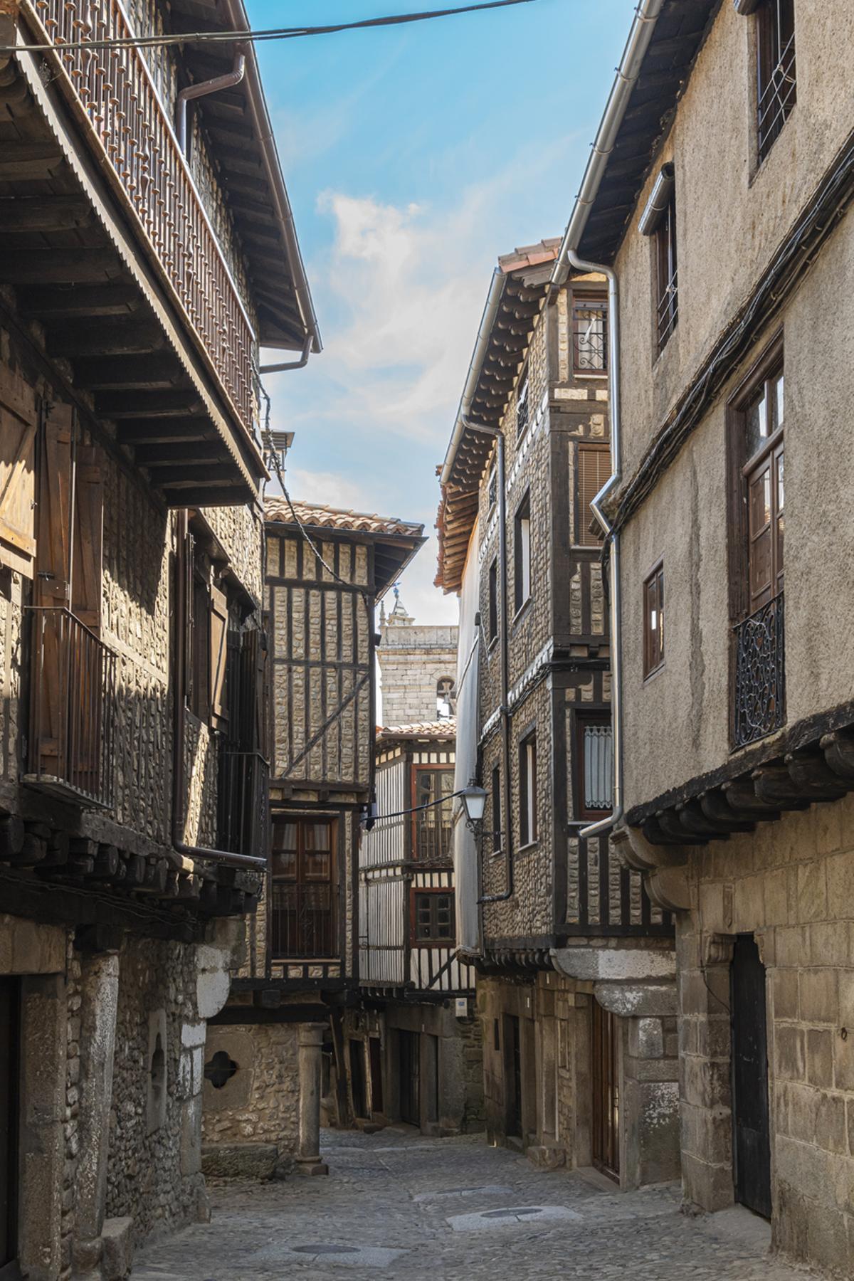 Una estrecha calle peatonal empedrada con casas de arquitectura medieval