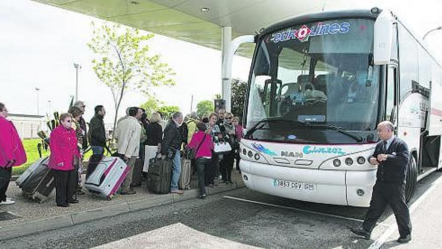 De arriba abajo, panel informativo en la sala de llegadas del aeropuerto, un grupo de jubilados embarcando en un autobús con destino a Madrid, un hombre con su hijo jugando al fútbol en la terminal de Santiago del Monte y Elena San Emeterio junto a su familia tras conocer la cancelación de su vuelo a Londres.