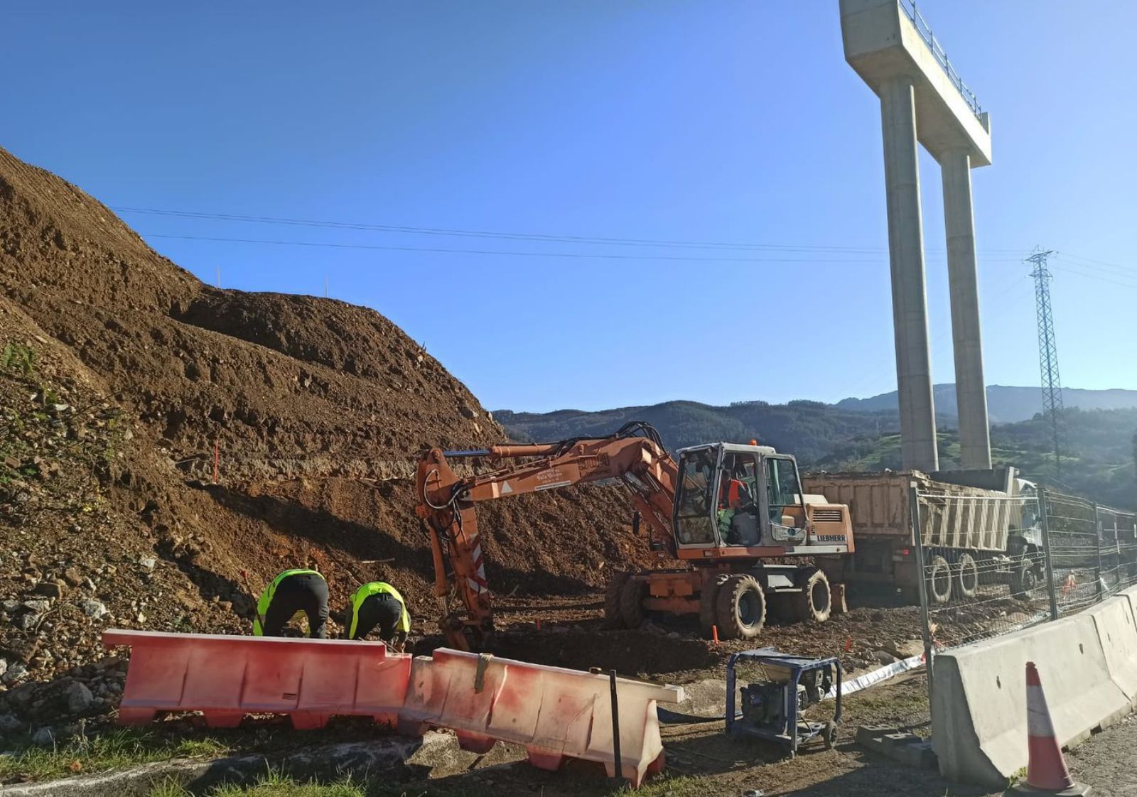 Operarios trabajando con la nueva maquinaria, ayer, en la zona del puente de La Barrosa (Salas). | Sara Arias