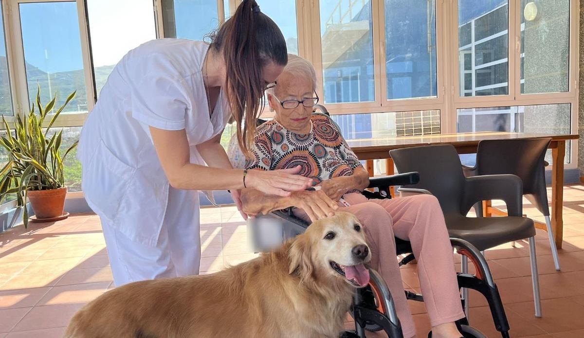 Rosa acariciando a Kenna junto con la terapeuta Moneyba