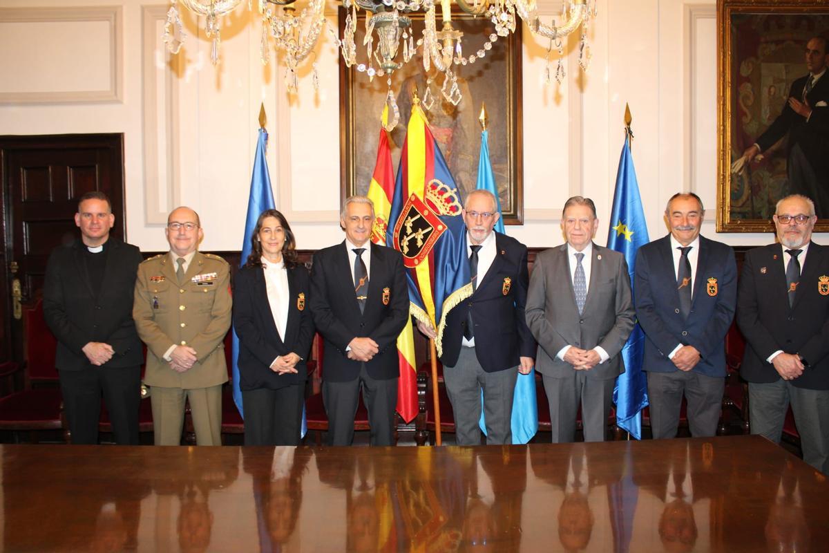 Por la izquierda, el capellán castrense, Juan Luis García; Jesús Pina; Esmeralda Nuño; Fermín Olay; Ángel Albarracón con el Guión; Alfredo Canteli,; Juan Villalba y Cesáreo Suárez, en el salón de plenos municipal.
