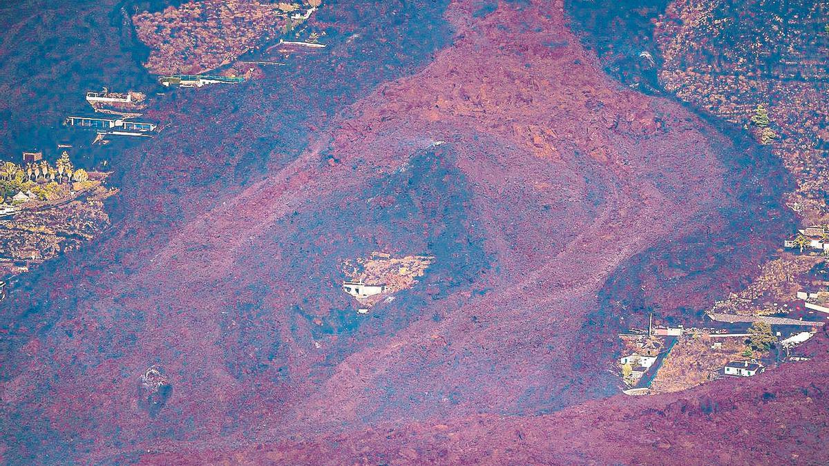 Imatge que mostra com la lava expulsada pel volcà sepulta les cases al seu pas