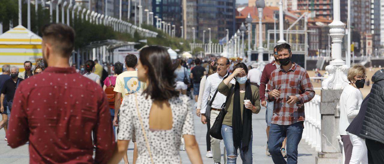 Gente por el paseo del Muro en Gijón.