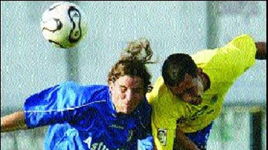 El oviedista Lucas choca con un jugador de Las Palmas.