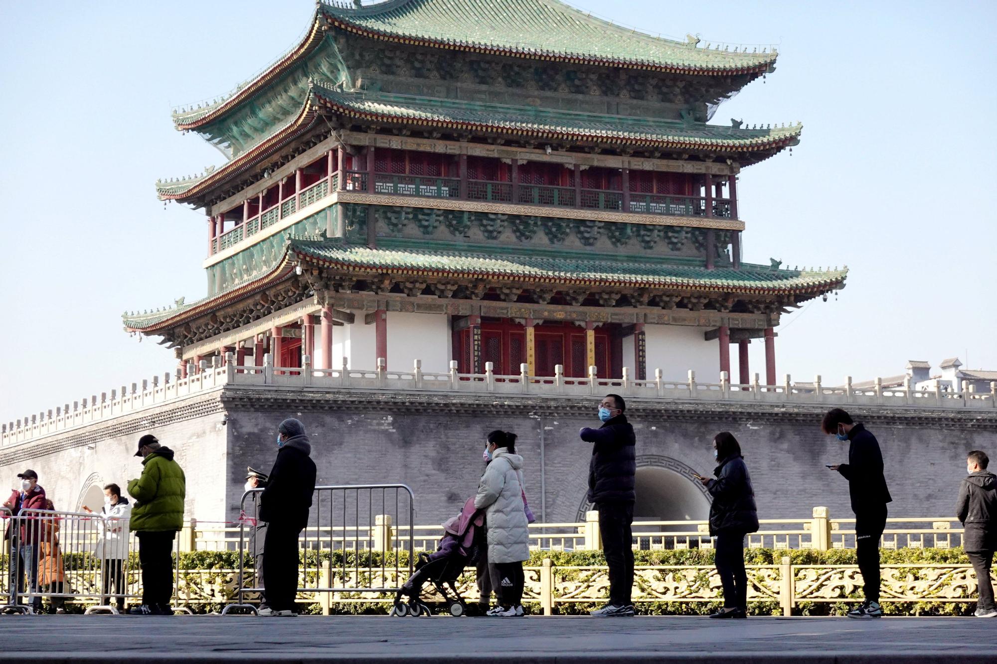 Gente haciendo cola con mascarilla en la ciudad china de Xian