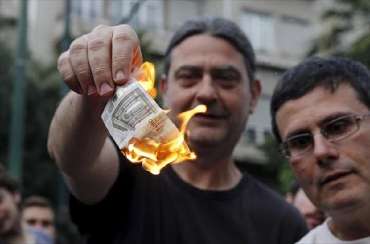 Un manifestant contra l’austeritat crema cinc euros a Atenes.