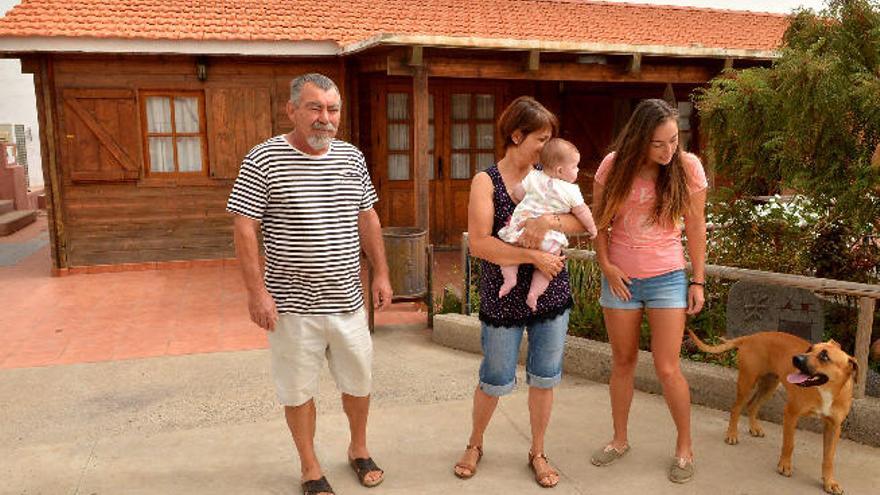 Parte de la familia Medina Calcines delante de la casa que tiene una orden de demolición.