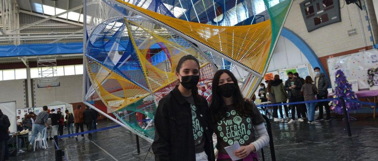 Por la izquierda, Ariam Fernández y María Iglesias, con el cubo geométrico que da la bienvenida a la feria. | A. M. S.