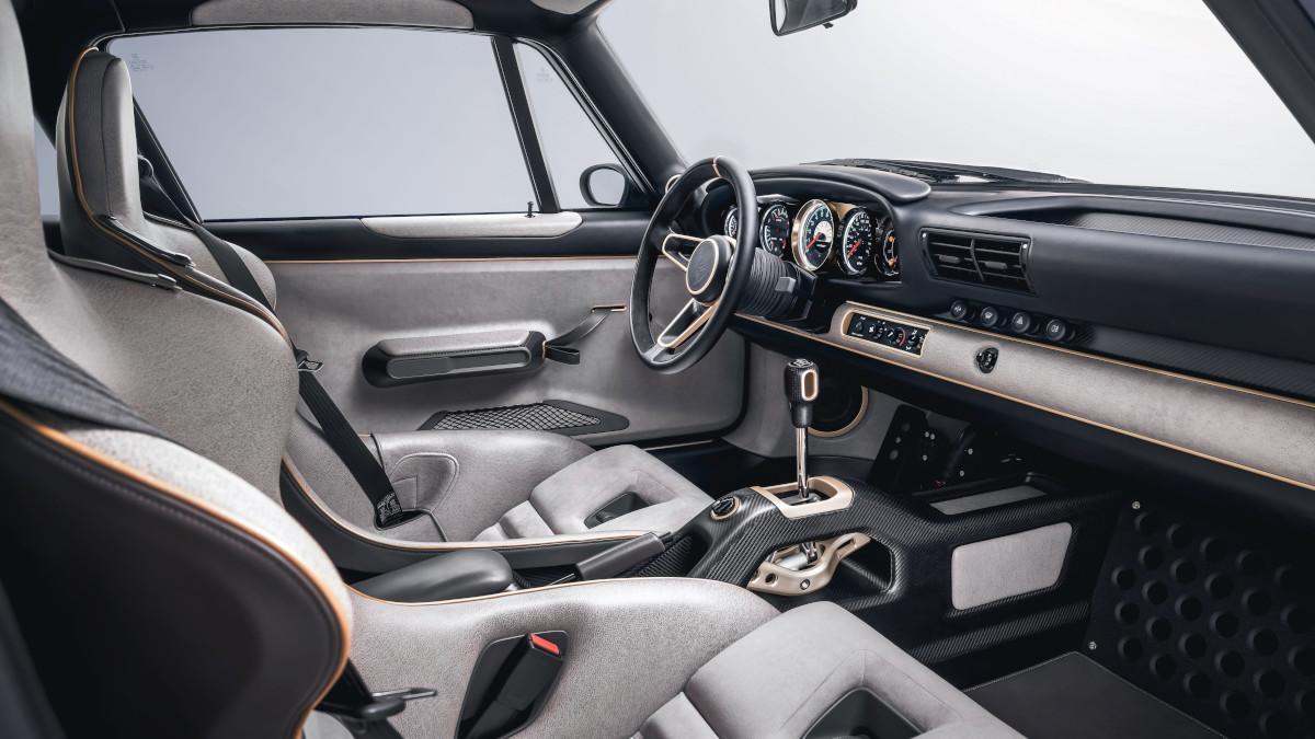 El habitáculo mezcla Pebble Grey y Alcantara Pearl Grey, con detalles Champagne y un ambiente sobrio centrado en el conductor.