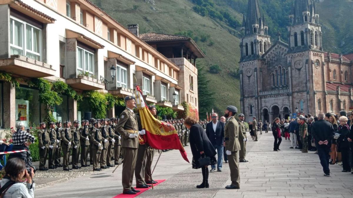 Una mujer hace una reverencia ante la bandera de España, en la jura para personal civil en el real sitio de Covadonga. | Julia Quince