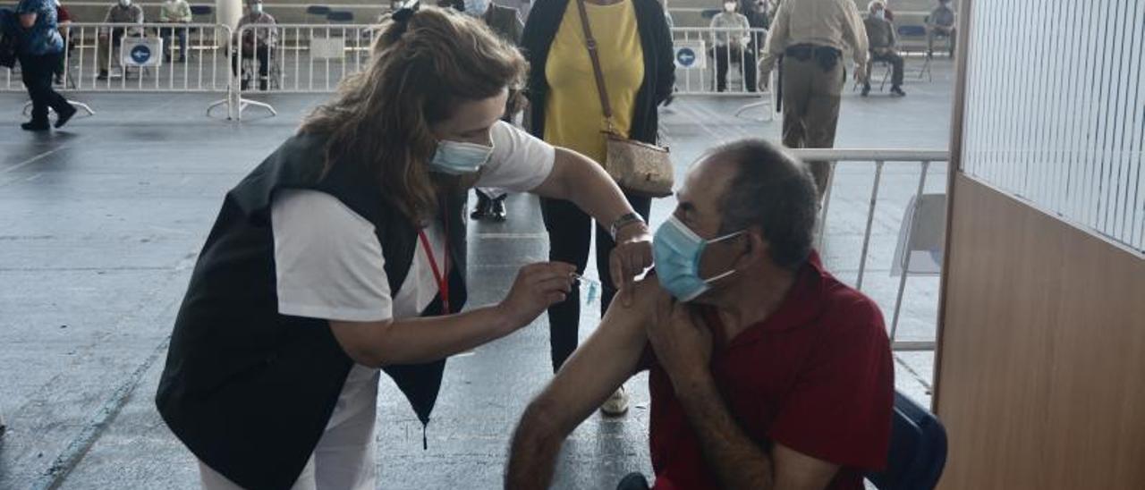 Un hombre recibie la vacuna de Pfizer en el Recinto Ferial de Pontevedra.  // RAFA VÁZQUEZ