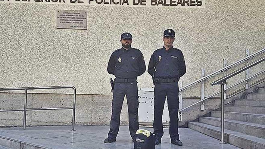 El agente Francisco Alonso y Gustavo, el jefe del grupo, con el desfibrilador en la Jefatura.