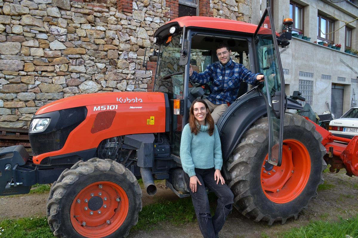 Arián y Noelia con el tractor con el que trabajan.