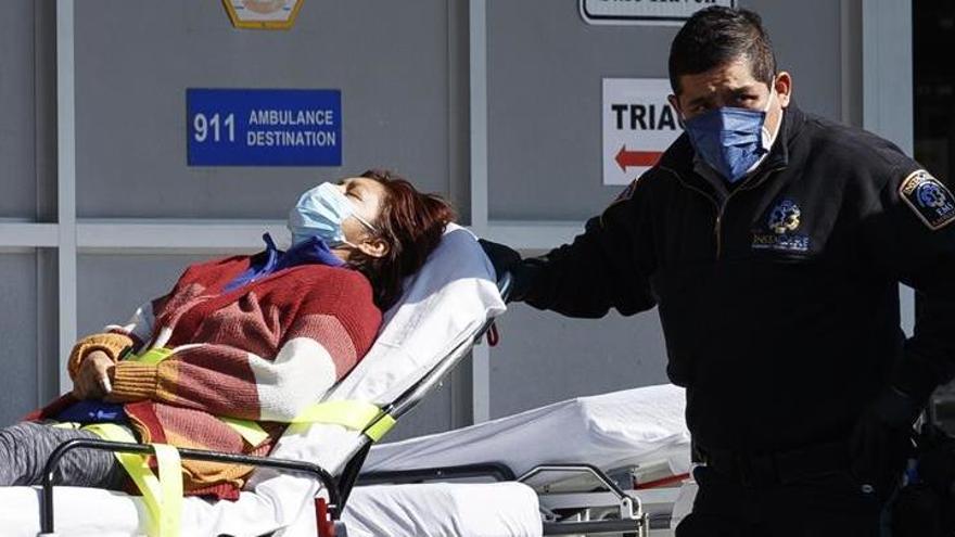 Un paramédico atendiendo a una paciente de covid-19 en Brooklyn.