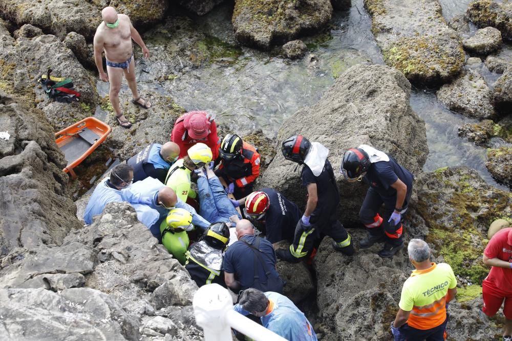 Rescatan a una mujer que se precipitó a las rocas de la playa de San Lorenzo en Gijón.