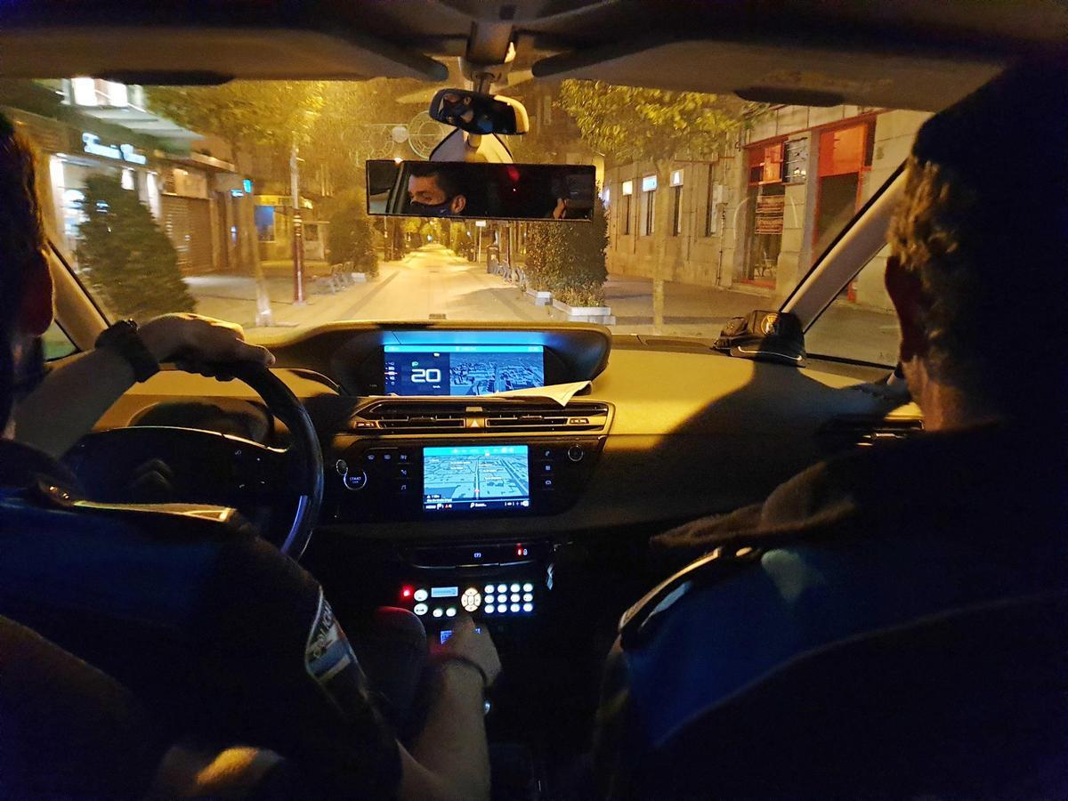 Una patrulla de la Policía Local recorre de noche una céntrica calle de Vigo.