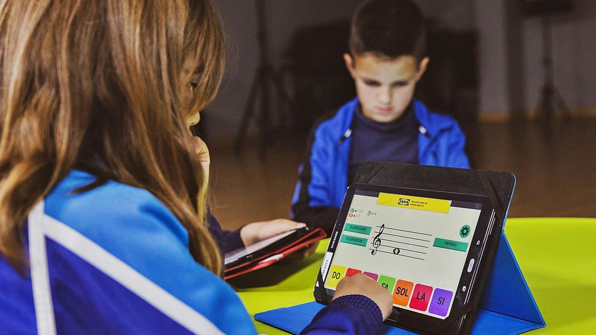 Dos xiquets fan les activitats musicals amb la tablet. | LEVANTE-EMV