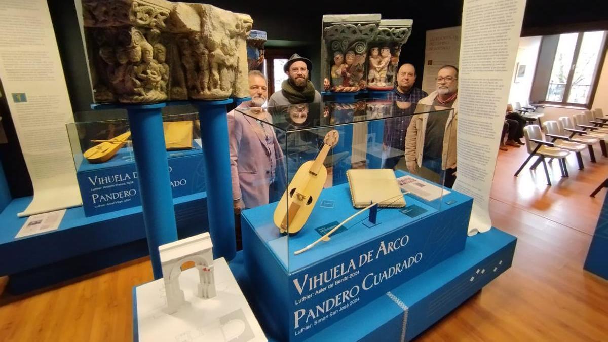 Por la izquierda, Manuel Paz, Simón San José, Fernando Oliva y Roberto García, junto a la vihuela de arco y el pandero cuadrado que aparecen en los capiteles de la iglesia de Ciaño, recreados a los lados. | M. Á. G.