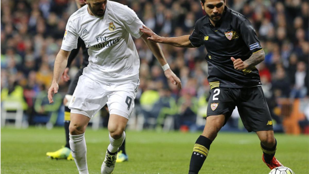 El delantero francés del Real Madrid Karim Benzema (izquierda) pelea un balón con el defensa francés Benoît Trémoulinas durante el partidos de la Liga 2015/16 entre ambos equipos en el Santiago Bernabéu