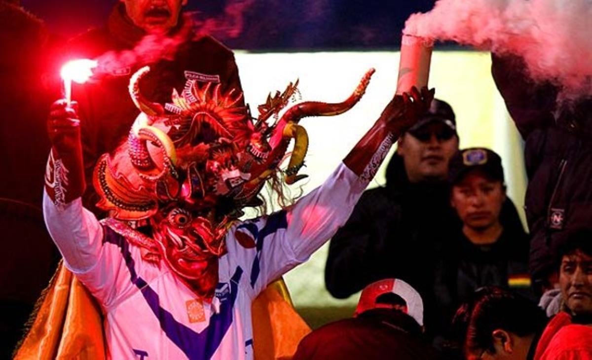 Un aficionado del club boliviano de fútbol San José, vestido como un diablo, vitorea a su equipo durante un partido de la Copa Sudamericana contra el equipo argentino Newell’s Old Boys en Oruro (Bolivia).