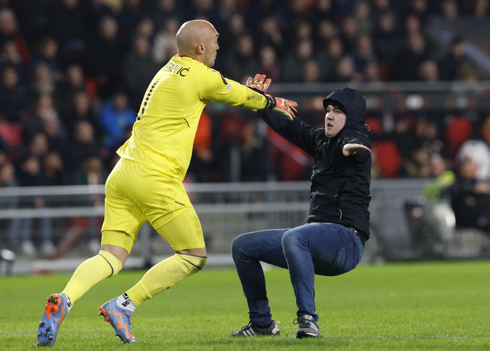 Un espectador salta al campo durante el PSV-Sevilla e intenta agredir a Dmitrovic