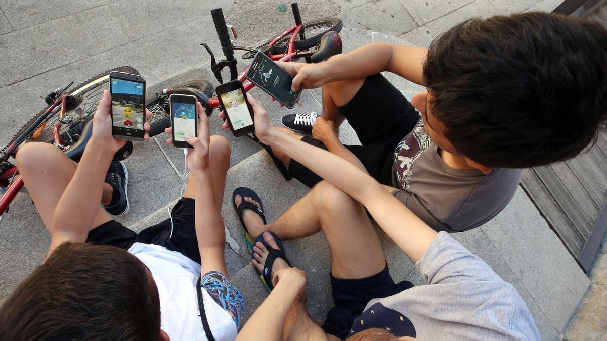 Jóvenes con un juego en su móvil.