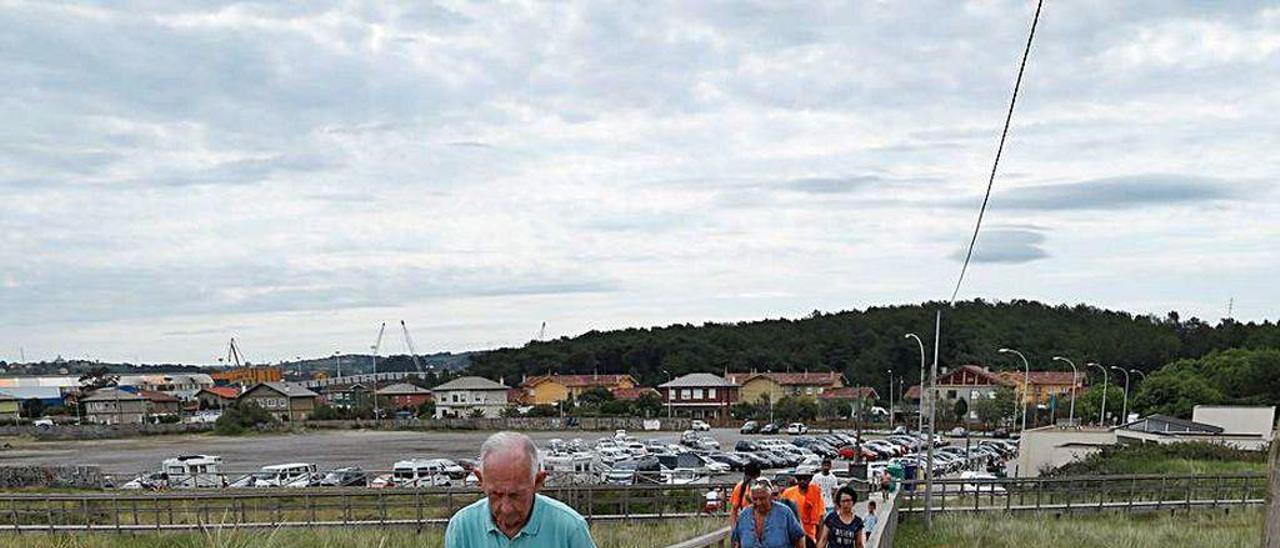 Bañistas accediendo ayer a la playa de San Juan por las pasarelas cubiertas de arena.