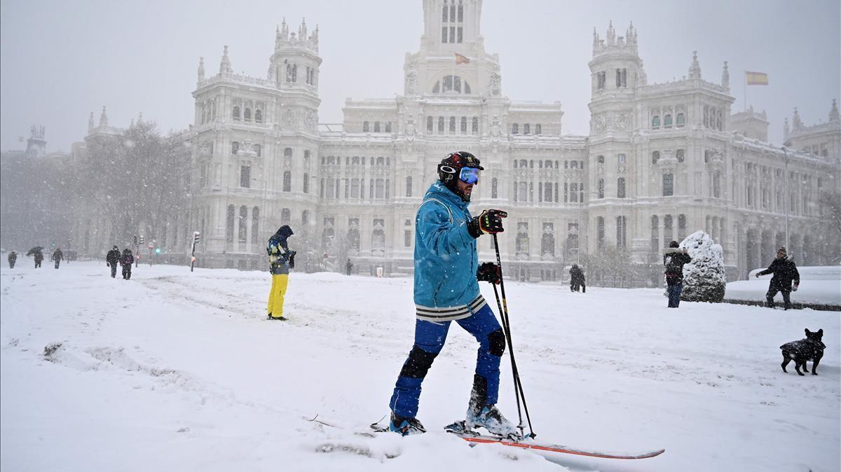 Un hombre con los esquís en la Plaza de la Cibeles de Madrid