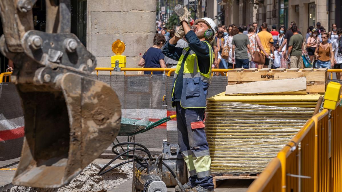 Un trabajador de una obra de Barcelona hace una pausa para hidratarse durante su jornada laboral.