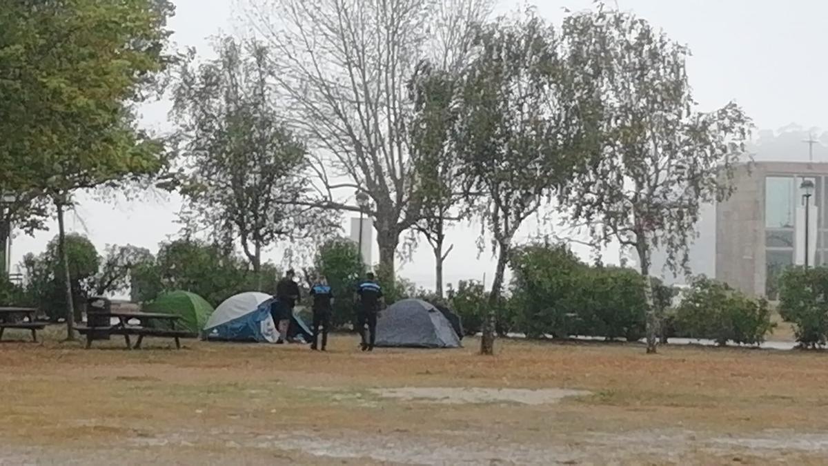 Agentes de la Policía Local desalojan las tiendas de campaña en la playa de Cesantes. / C.R.